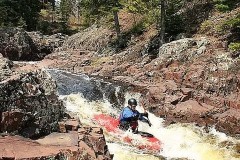 Spring kayakers with the lodge above